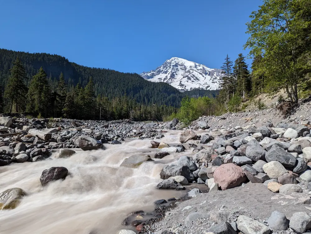 View of Mount Rainier from miles away, water rushing, rocky landscape at Mount Rainier National Park