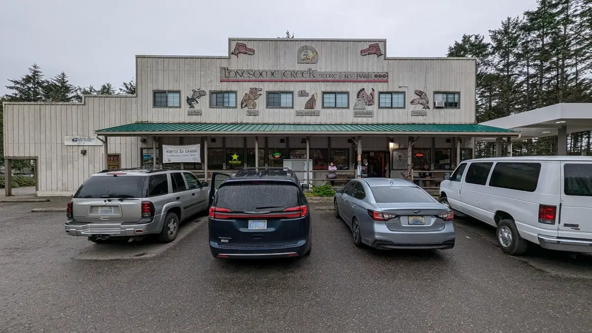 Lonesome Creek Store Resort La Push The exterior of Lonesome Creek Store & RV Park building at La Push, Washington, with parked cars and a gas pump in front.