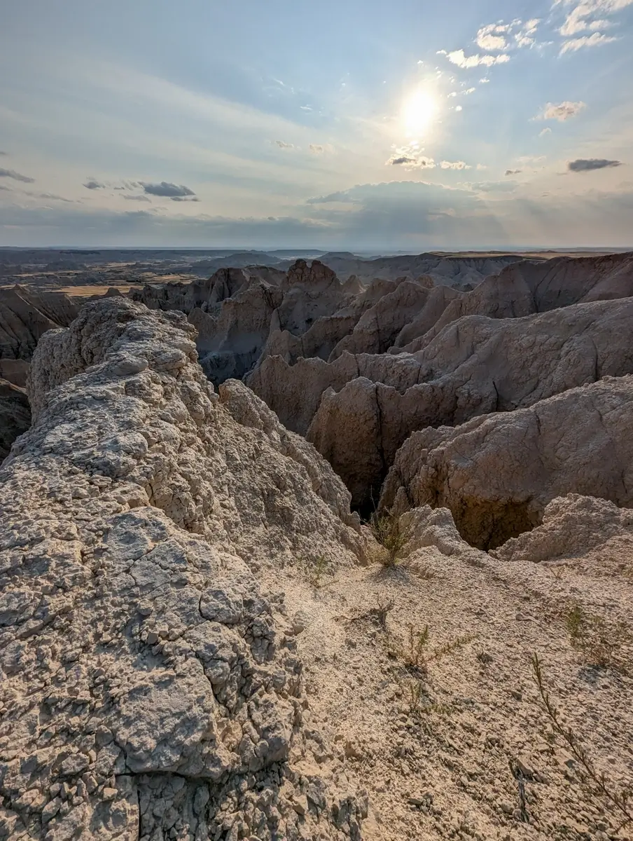 Ancient Hunters Overlook Badlands Close-up view of the rugged, cracked white rock edge at Ancient Hunters Overlook overlooking the Badlands landscape at sunset.