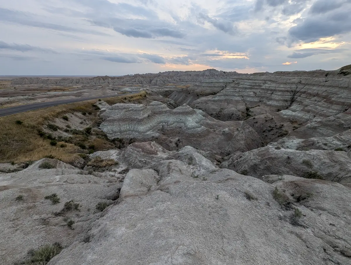 Near Yellow Mounds Overlook Badlands Layered, colored sediment hills near the Yellow Mounds Overlook in Badlands National Park with a road visible on the left.