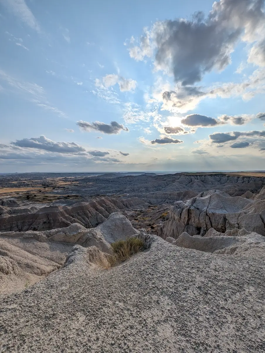 Pinnacles Overlook Badlands SD Panoramic view of the Badlands National Park formations at Pinnacles Overlook under a blue sky with scattered clouds.