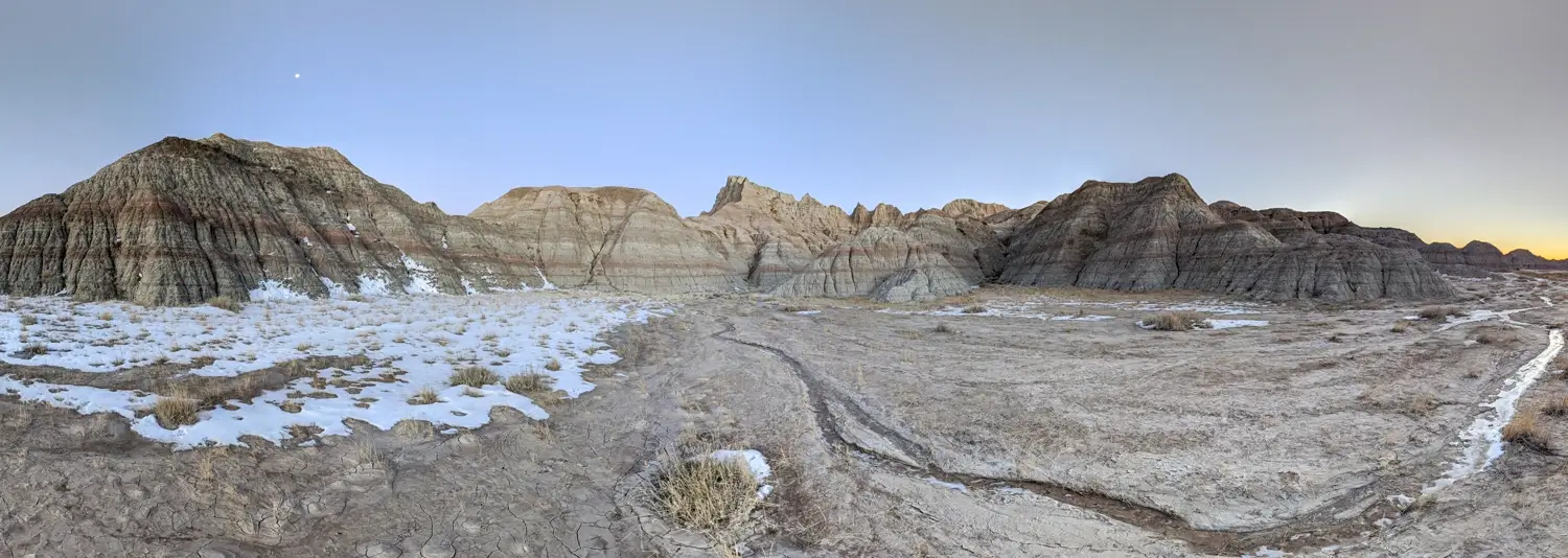 Badlands Striation NP Panorama of colorful sedimentary rock layers and geological striations in Badlands National Park, South Dakota, with a light dusting of winter snow.
