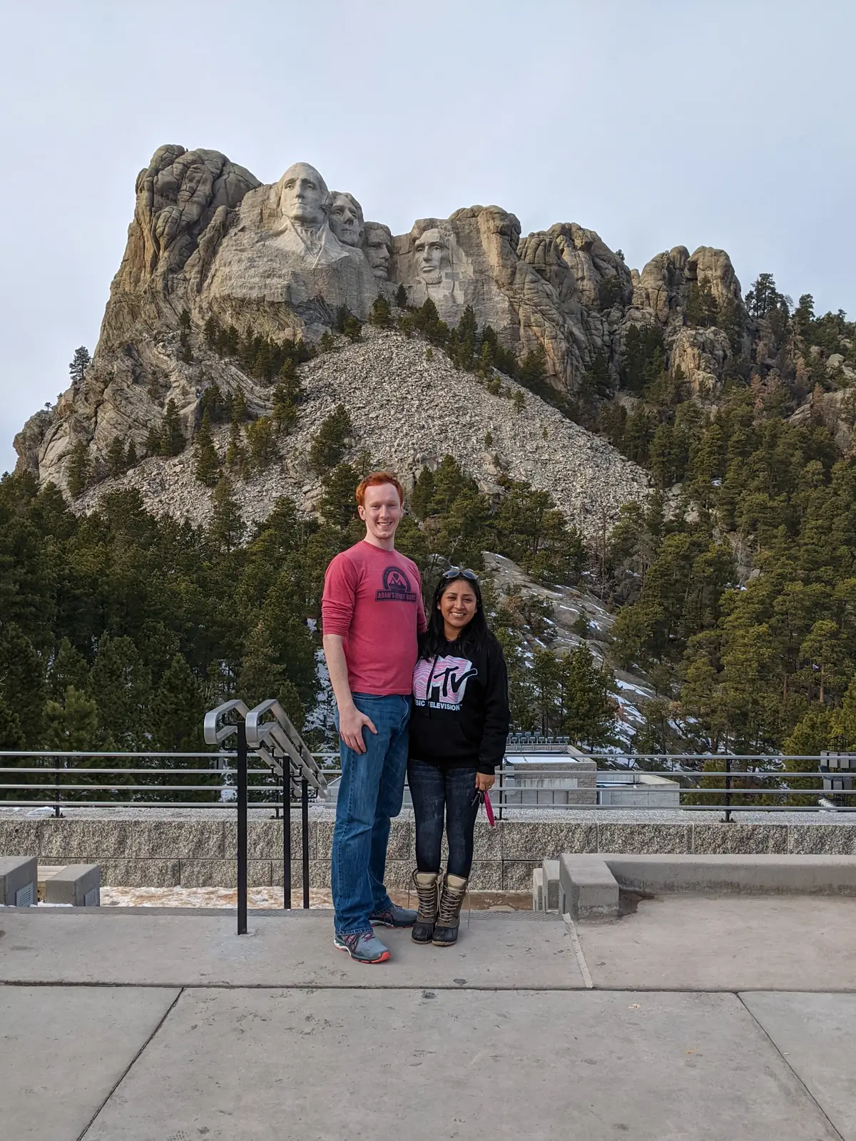 Sam and Minerva standing at the main viewing platform of Mount Rushmore National Memorial on a quiet day in January.