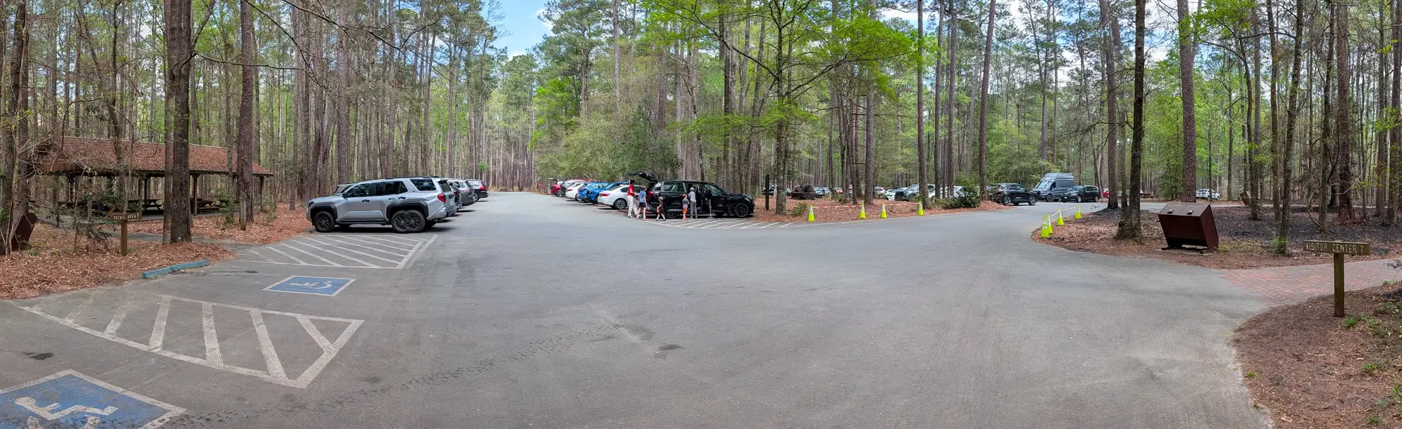 The main parking area and visitor center access for the Boardwalk Loop Trail at Congaree National Park, showing shaded spots and picnic shelters.